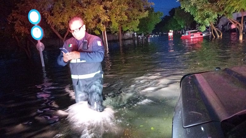 Cuerpos de emergencias auxilian a automovilista afectados por inundación en Juriquilla.