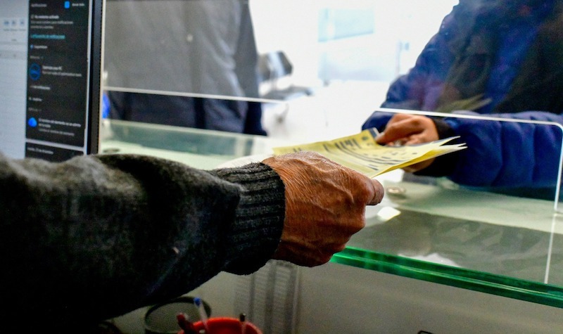 Persona entregando documentos en ventanilla